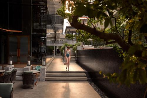 a woman walking down the stairs of a building at Homm Sukhumvit34 Bangkok in Bangkok