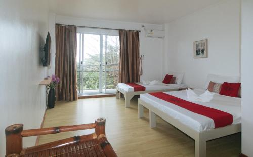 a hotel room with two beds and a window at RedDoorz at Garvs Boutique Hotel Boracay in Boracay