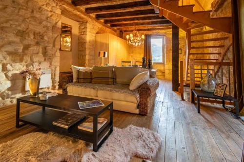 un salon avec un canapé et une table dans l'établissement Maison de charme entre Château et Rivière Dordogne - Périgord, à Castelnaud-la-Chapelle