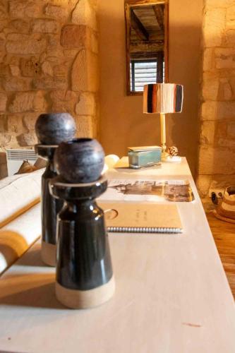 Deux bouteilles assises sur une table à côté d'un bureau dans l'établissement Maison de charme entre Château et Rivière Dordogne - Périgord, à Castelnaud-la-Chapelle