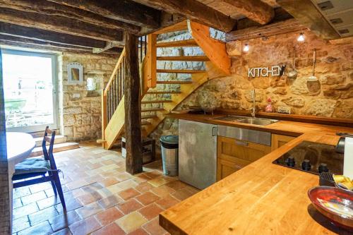 - une cuisine avec un comptoir et un escalier dans une pièce dans l'établissement Maison de charme entre Château et Rivière Dordogne - Périgord, à Castelnaud-la-Chapelle