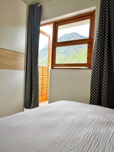 a bedroom with a bed and a window with a view at El Paraíso Agaete Valle in Agaete