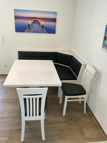 a white table and two chairs in a room at Ruhig gelegene EG-Neubauwohnung mit Garten, Terrasse, Insektenschutz, Einbauküche für max 7 Personen in Südlohn