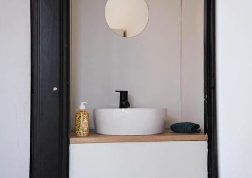 a bathroom sink on a wooden shelf with a mirror at City suite 3 in Eindhoven