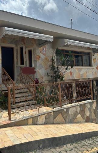 a stone house with a porch and a balcony at ALAMEDA iNN in Poços de Caldas