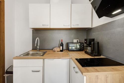 a kitchen with white cabinets and a sink and a microwave at Altstadt Residenz in Lübeck