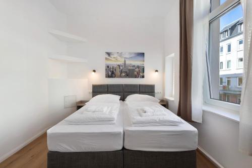 a bedroom with two beds and a large window at Altstadt Residenz in Lübeck