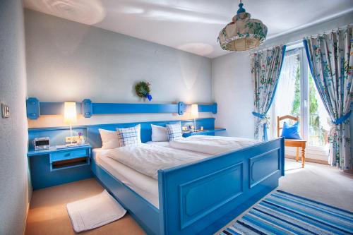 une chambre bleue avec un grand lit et une tête de lit bleue dans l'établissement Ferienwohnung Christiane - Steilhofweg / Feuerwehrheimstrasse, à Bad Reichenhall