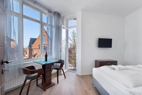 a bedroom with a bed and a desk and a window at Altstadt Residenz in Lübeck