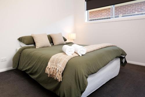 a bedroom with a bed with two towels on it at Luxury Golfers Escape Yarrawonga in Yarrawonga