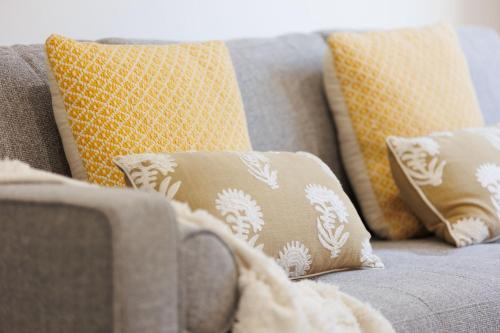 a gray couch with pillows on top of it at Luxury Golfers Escape Yarrawonga in Yarrawonga