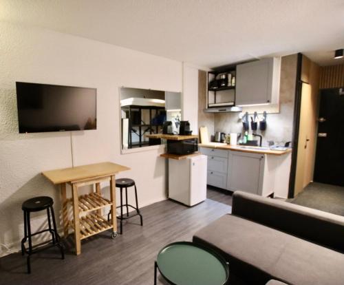 un salon avec un canapé et une table et une cuisine dans l'établissement Chamonix Sud studio with Mont Blanc views, à Chamonix-Mont-Blanc