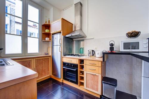 Il comprend une cuisine équipée d'une cuisinière. four supérieur à côté d'une fenêtre dans l'établissement L'Écrin Blanc Niçois - Welkeys, à Nice