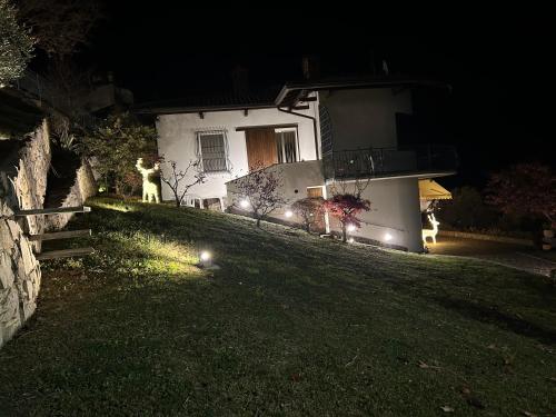 a house with a dog standing in the yard at night at Casa Vacanza SK in Bianzano
