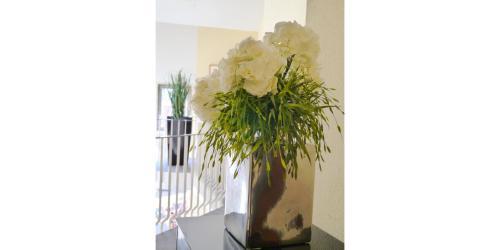 a vase filled with white flowers on a shelf at Hotel am Stadtgarten in Radolfzell am Bodensee