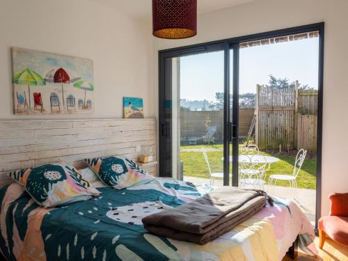 プルガヌーにあるVilla lumineuse vue mer 150m plageのベッドとガラスの引き戸のある寝室