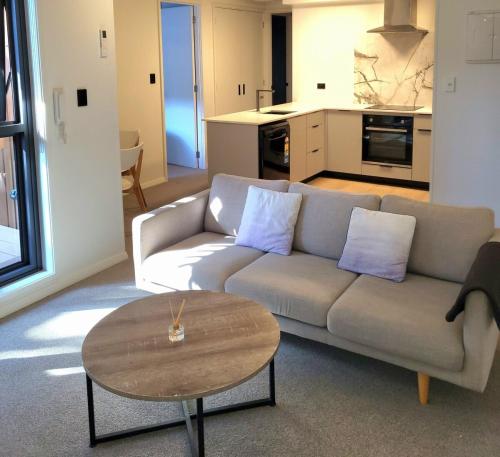 a living room with a couch and a table at Epsom Escape Stylish Apartment in Auckland