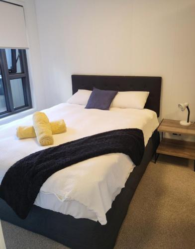 a bedroom with a large bed with yellow pillows at Epsom Escape Stylish Apartment in Auckland