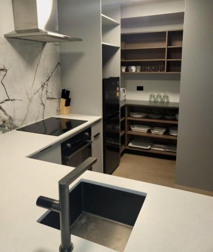 a kitchen with a white counter top and a stove at Epsom Escape Stylish Apartment in Auckland
