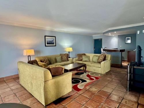 a living room with two couches and a table at Quality Inn & Suites Gulf Breeze Bayside near Pensacola Beach in Gulf Breeze