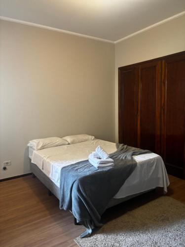 a bedroom with a bed and a wooden cabinet at ALAMEDA iNN in Poços de Caldas