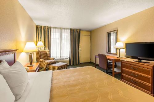 a hotel room with a bed and a flat screen tv at Quality Inn & Suites McDonough South I-75 in McDonough