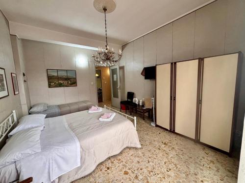 a bedroom with a large bed and a chandelier at Lg Giarre Apartment in Italy in Giarre