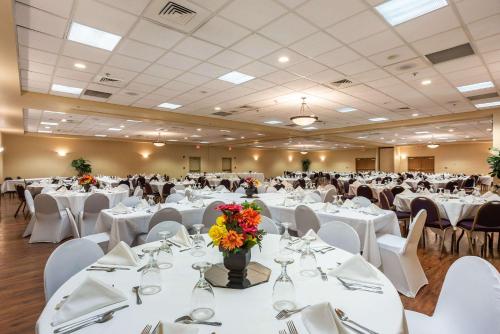 a banquet hall with white tables and white chairs at Quality Inn & Suites Hannibal West in Hannibal