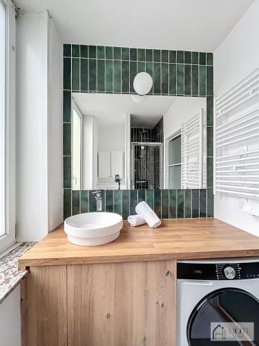 une salle de bain avec une baignoire, un lavabo et un miroir dans l'établissement Petit Cocon - Confort & Moderne, à Dunkerque