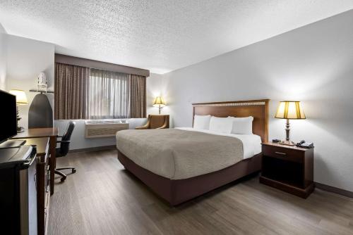 a hotel room with a bed and a desk at Quality Inn near Monument Health Rapid City Hospital in Rapid City