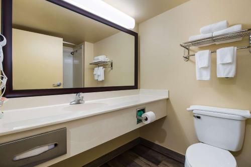 a bathroom with a sink and a mirror and a toilet at Quality Inn & Suites North Myrtle Beach in Myrtle Beach