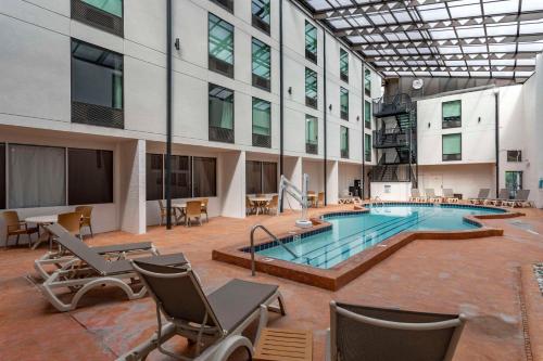 a large pool in a building with chairs and a building at Comfort Inn & Suites Nashville Downtown - Stadium in Nashville