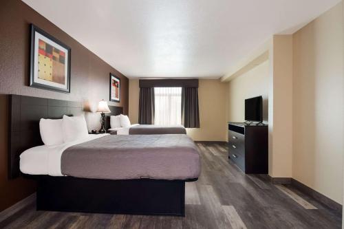 a hotel room with two beds and a television at Quality Inn & Suites North Myrtle Beach in Myrtle Beach