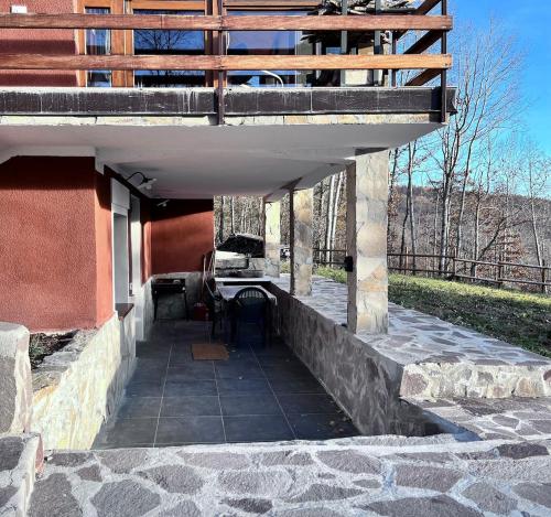 a porch of a building with a deck on top at La casa nel bosco in Brallo di Pregola