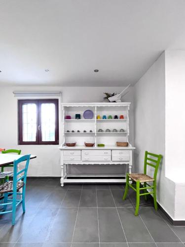 a room with a white shelf and two chairs and a table at La casa nel bosco in Brallo di Pregola