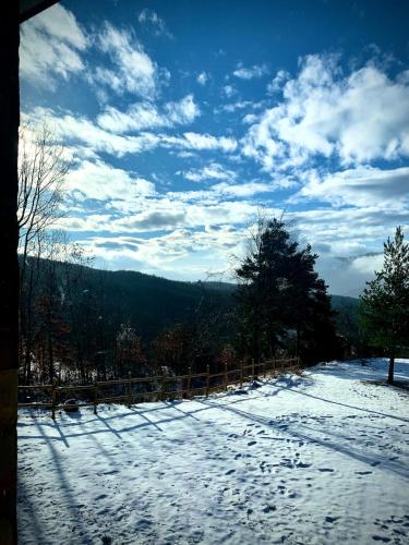 a snow covered yard with a fence and a sky at La casa nel bosco in Brallo di Pregola