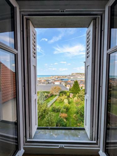 une fenêtre ouverte avec vue sur la ville dans l'établissement Maison vue mer avec jardin - Villa Trabendo, au Tréport