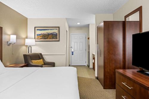 a hotel room with a bed and a chair and a television at Comfort Inn Worland Hwy 16 to Yellowstone in Worland