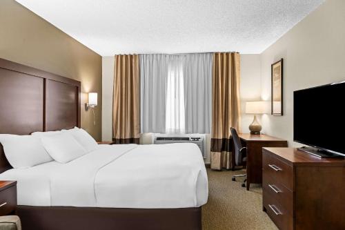 a hotel room with a bed and a desk and a television at Comfort Inn Worland Hwy 16 to Yellowstone in Worland
