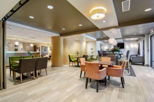 a dining room with tables and chairs and a bar at Comfort Inn Raleigh Midtown in Raleigh