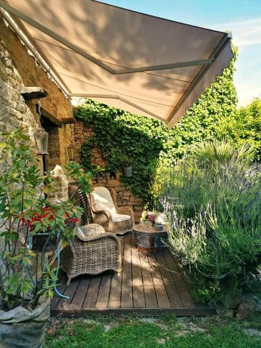 a patio with an umbrella and chairs on a wooden deck at Antica Locanda Lunetta in Màndas