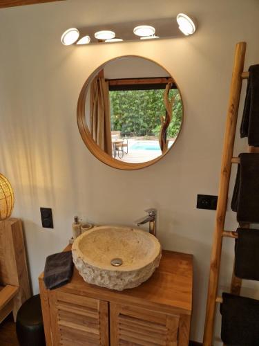 une salle de bain avec un lavabo en pierre et un miroir dans l'établissement La Cabane de Cinette, à Vallabrègues