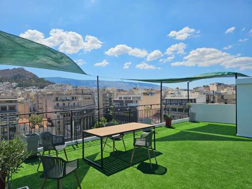 a patio with a table and chairs on a balcony at Lycabettus View Kaniggos in Athens