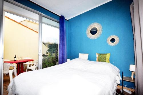 une chambre avec un mur bleu et un lit dans l'établissement Plain-pied près du Lydia - Patio, wifi & parking, au Barcarès