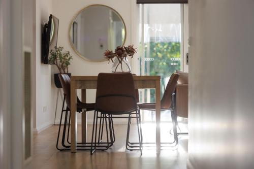 a dining room table with chairs and a mirror at Luxury Golfers Escape Yarrawonga in Yarrawonga