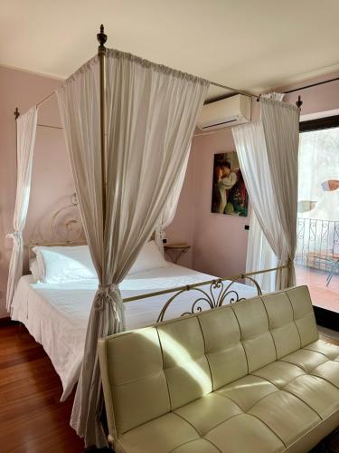 a bedroom with a canopy bed and a couch at Relais Ristori in Verona