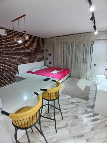 TurksibにあるЖК "Радужный" Аэропорт 1 комнатнаяのベッドとテーブルと椅子のある寝室