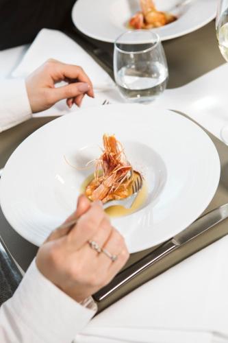a person sitting at a table with a plate of food at Easy Green Hotel in San Giovanni Rotondo