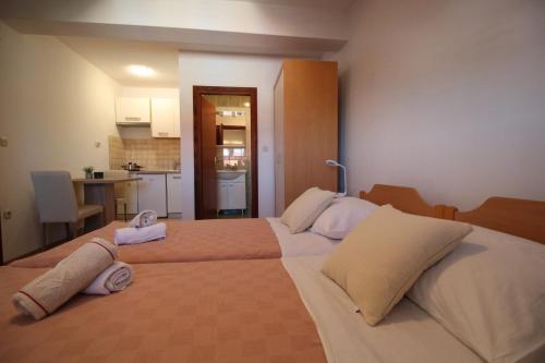 a bedroom with a large bed with two towels on it at Dolce Mare Apartmani in Pakoštane