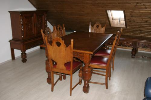 a dining room table with chairs and a wooden table at Villa Teleki in Teleki
